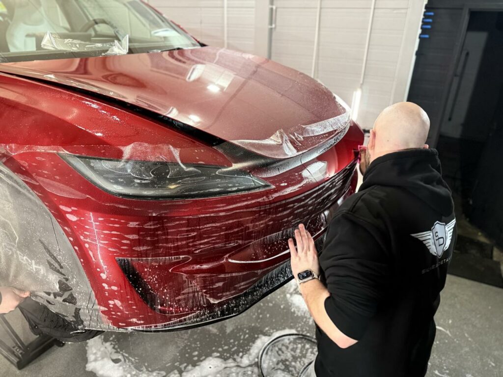 Specjalista Silver Detailing podczas oklejania Tesli folią ochronną PPF
